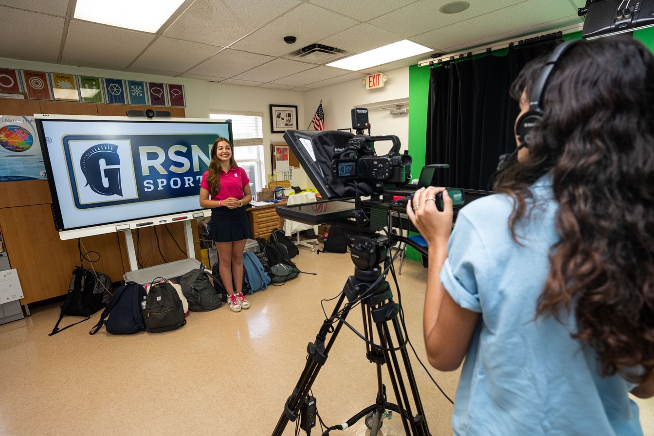 Two students filming Raider Student Network Sports